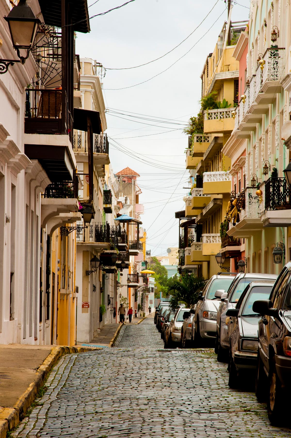 Pastel colonial buildings with iron balconies along cobblestoned Calle San Sebastián in Old San Juan